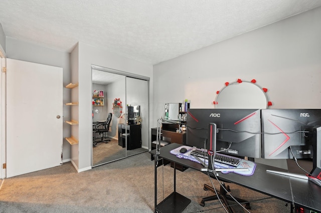 carpeted home office featuring a textured ceiling