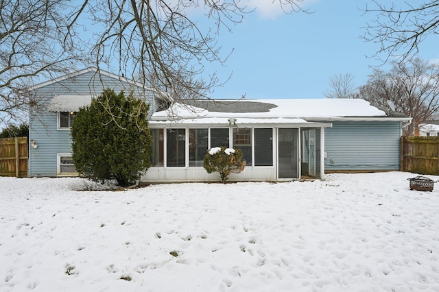 snow covered property with a sunroom