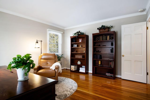 living area with ornamental molding, wood finished floors, and baseboards