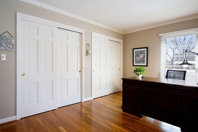 office space with ornamental molding, wood finished floors, and baseboards