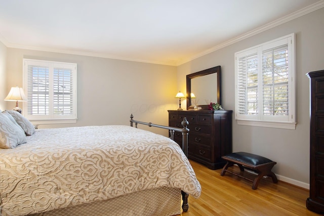 bedroom with light wood-style flooring, multiple windows, baseboards, and crown molding