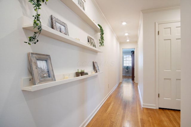 hall featuring ornamental molding, light wood-type flooring, baseboards, and recessed lighting