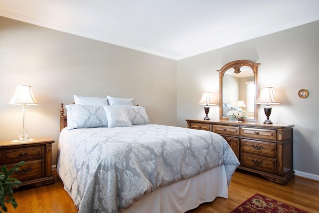 bedroom featuring crown molding, baseboards, and light wood-style floors