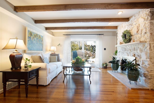 sitting room featuring a fireplace, wood finished floors, and beam ceiling