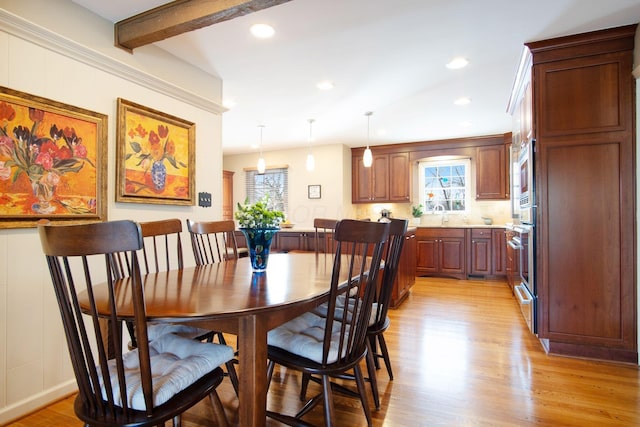 dining area featuring beam ceiling, light wood-style flooring, and recessed lighting