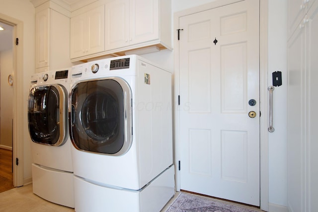 washroom with cabinet space and washer and dryer