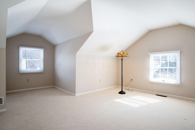 bonus room featuring lofted ceiling, visible vents, and a wealth of natural light