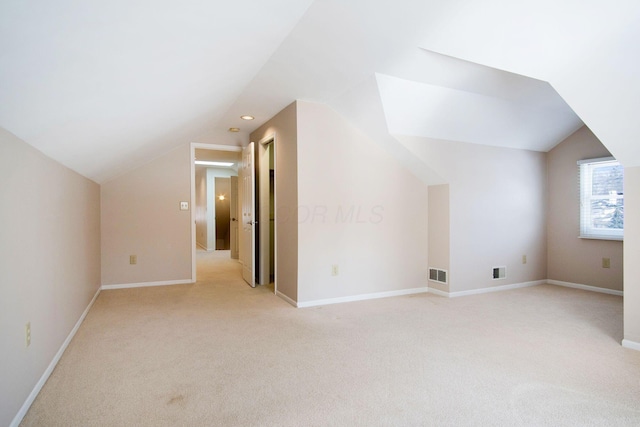 bonus room with lofted ceiling, light carpet, visible vents, and baseboards