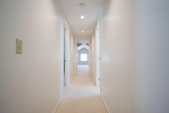 hall featuring light carpet, recessed lighting, baseboards, and lofted ceiling