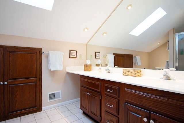 bathroom with double vanity, lofted ceiling with skylight, a sink, and visible vents