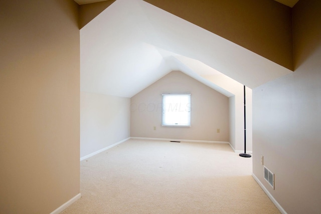 additional living space with lofted ceiling, baseboards, visible vents, and carpet