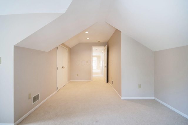 additional living space featuring light carpet, baseboards, visible vents, lofted ceiling, and recessed lighting