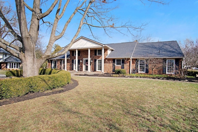 greek revival house featuring brick siding and a front yard