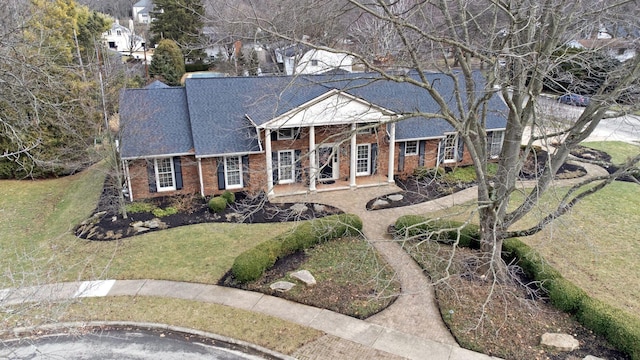 greek revival inspired property featuring brick siding and a front lawn