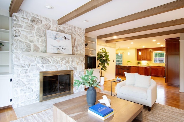 4580 Helston Ct, Columbus, OH 43220 - living room with light wood-type flooring, beamed ceiling, a fireplace, and recessed lighting