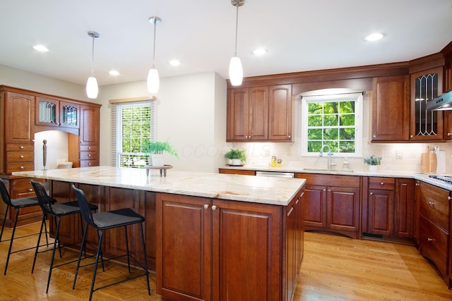 4580 Helston Ct, Columbus, OH 43220 - kitchen with a kitchen island, a sink, plenty of natural light, backsplash, and recessed lighting