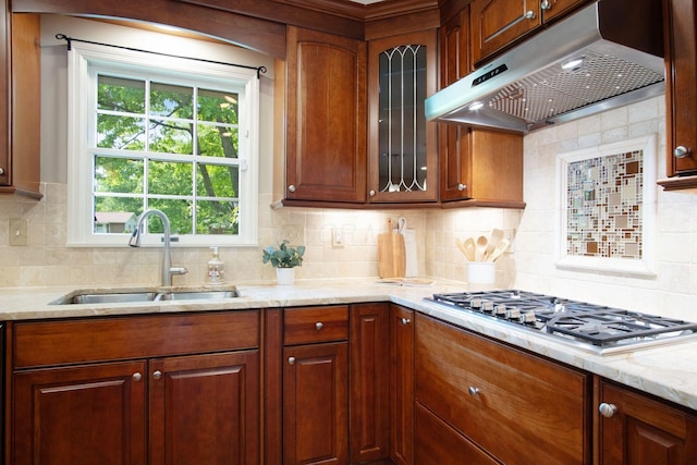 4580 Helston Ct, Columbus, OH 43220 - kitchen featuring under cabinet range hood, a sink, stainless steel gas stovetop, glass insert cabinets, and decorative backsplash
