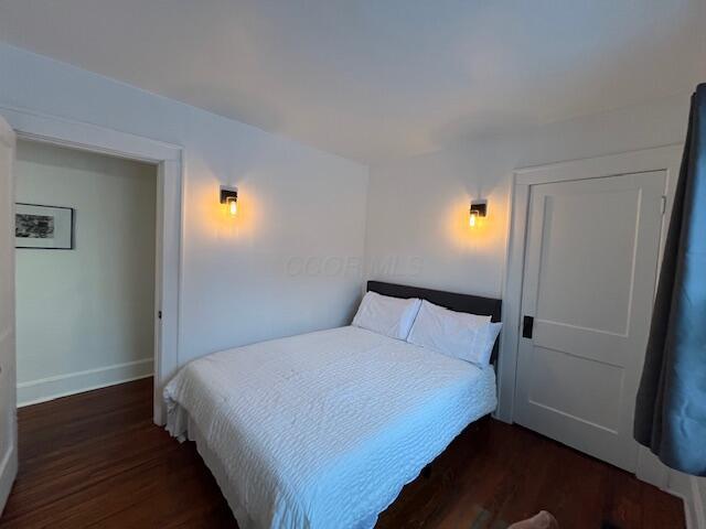 bedroom with dark hardwood / wood-style floors