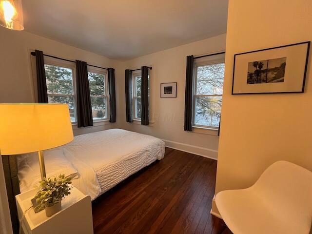 bedroom with dark hardwood / wood-style flooring