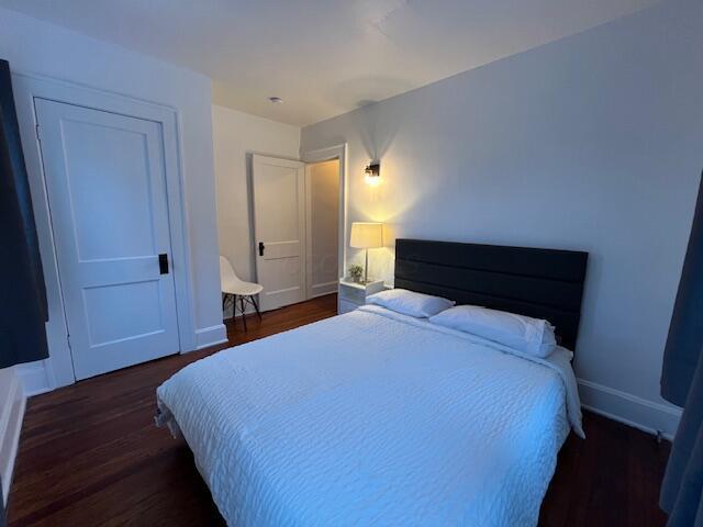 bedroom with dark wood-type flooring