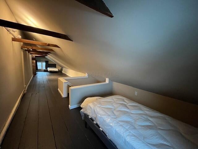 unfurnished bedroom featuring lofted ceiling and dark hardwood / wood-style flooring