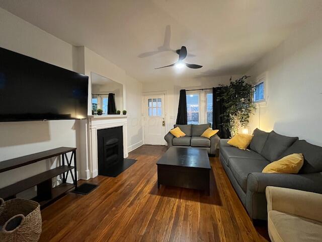 living room with ceiling fan and dark hardwood / wood-style floors