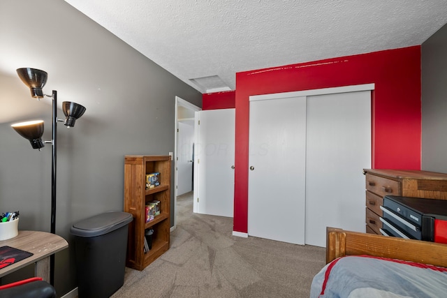 carpeted bedroom featuring a textured ceiling and a closet