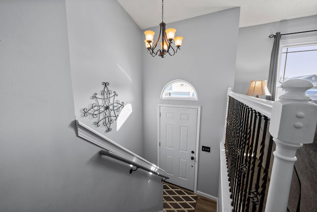 foyer featuring dark wood-type flooring and a notable chandelier