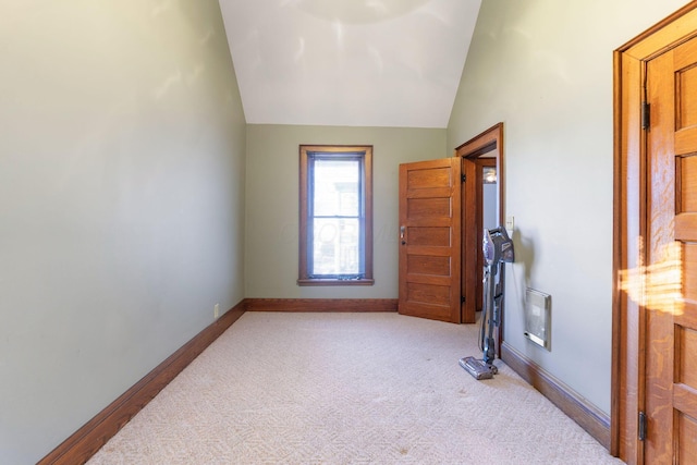 carpeted spare room with lofted ceiling and heating unit