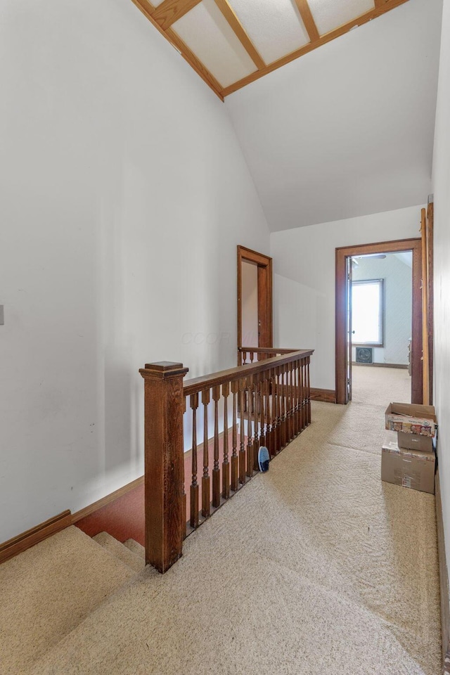 hallway with vaulted ceiling and carpet floors