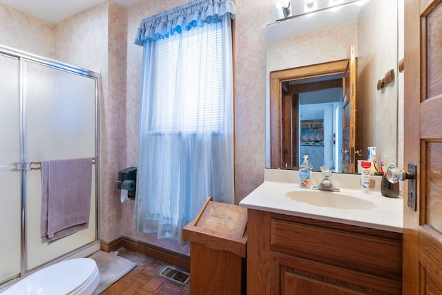 bathroom with walk in shower, vanity, parquet floors, and toilet