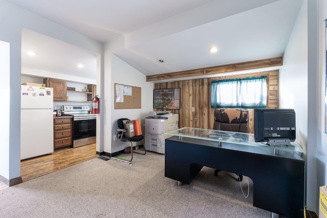 carpeted office featuring wood walls and beam ceiling