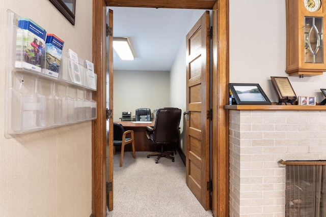 office with light colored carpet and a brick fireplace