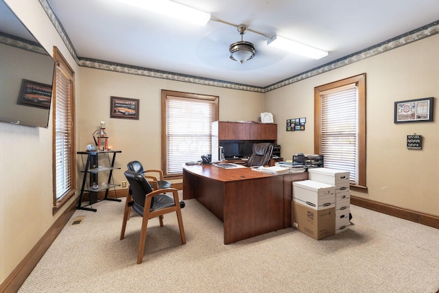 carpeted home office featuring ceiling fan and plenty of natural light