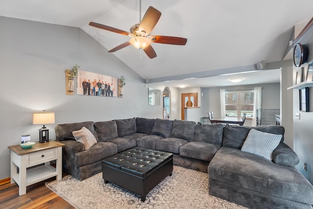 living room featuring ceiling fan, vaulted ceiling, and wood-type flooring