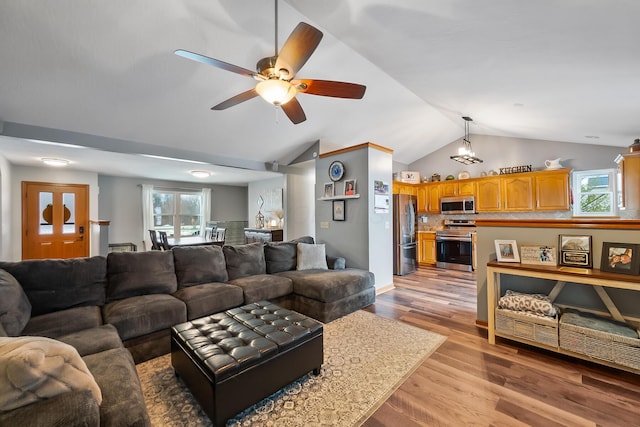 living room featuring lofted ceiling, ceiling fan, and light hardwood / wood-style floors