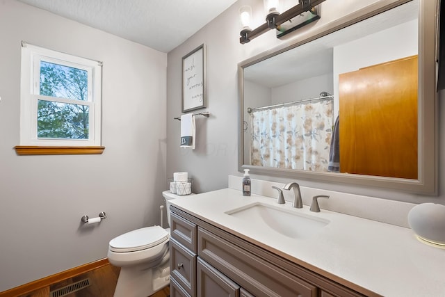 bathroom featuring toilet, vanity, and hardwood / wood-style flooring