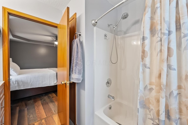 bathroom featuring ceiling fan, wood-type flooring, shower / bath combo, and a textured ceiling