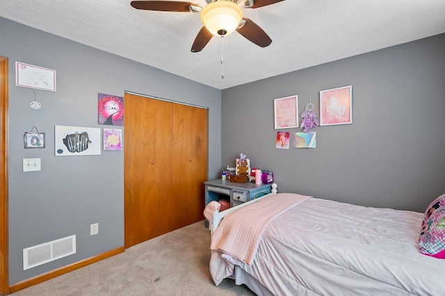 carpeted bedroom featuring ceiling fan and a closet