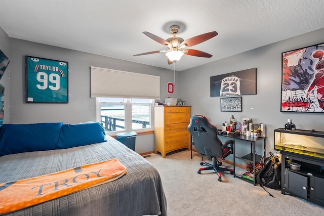 bedroom with a textured ceiling, ceiling fan, and light colored carpet