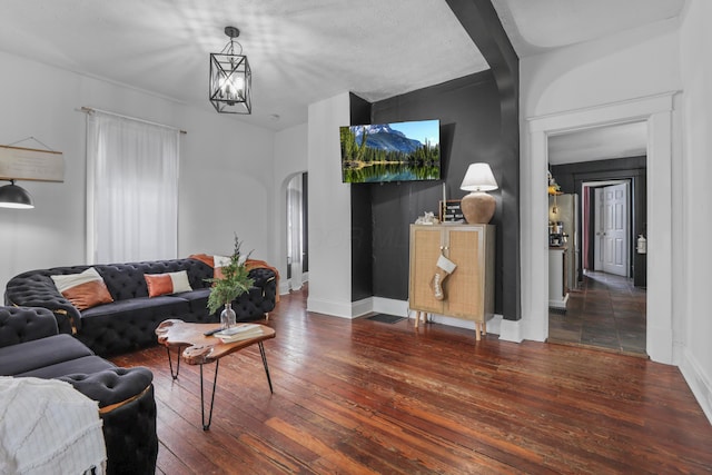 living room featuring a textured ceiling, dark hardwood / wood-style flooring, and a chandelier