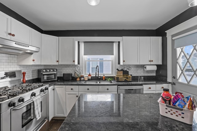 kitchen featuring sink, white cabinetry, appliances with stainless steel finishes, and dark stone counters