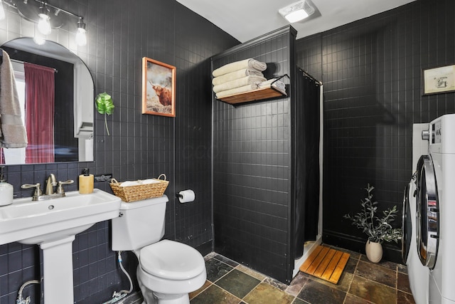 bathroom featuring washer / dryer, a shower with shower curtain, tile walls, and toilet