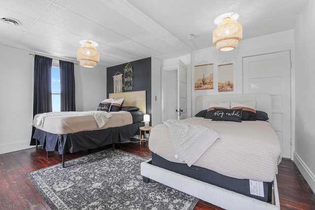 bedroom with dark hardwood / wood-style flooring and a paneled ceiling