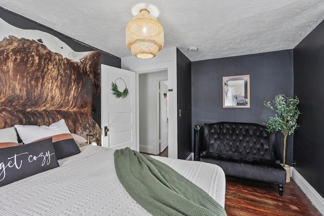 bedroom featuring a textured ceiling and dark hardwood / wood-style floors