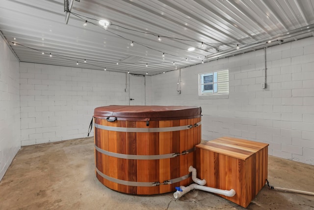 bar featuring a jacuzzi and concrete floors