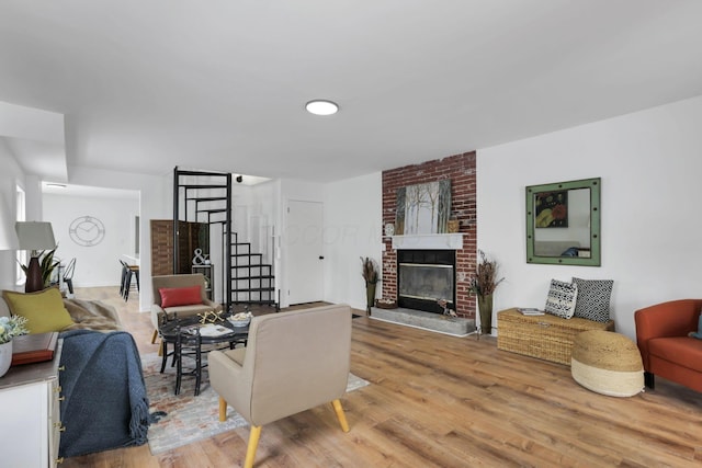 living room with a brick fireplace and hardwood / wood-style flooring