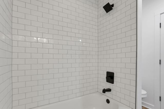 bathroom with tiled shower / bath and toilet