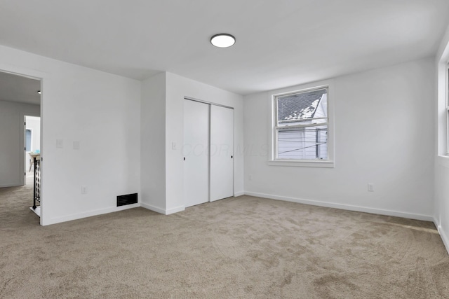 unfurnished bedroom featuring carpet and a closet