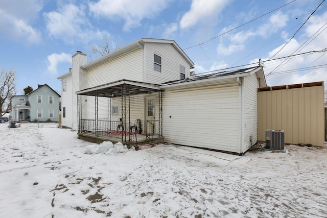 snow covered back of property with central air condition unit